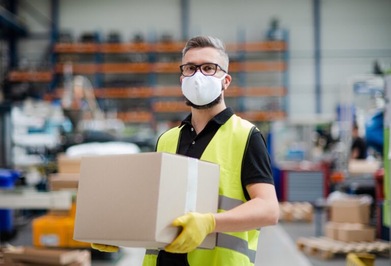 Man worker with protective mask working in industrial factory or warehouse