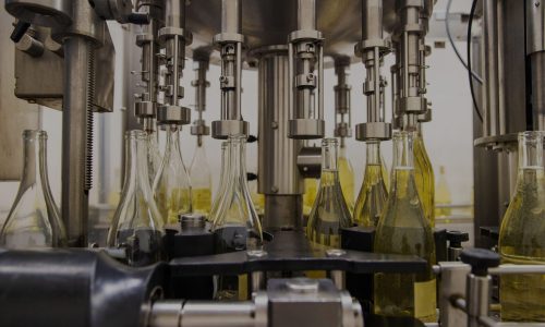 Maschinelle Befüllung von Glasflaschen in der Konsumgüterindustrie.
